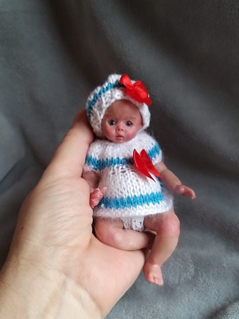 Miniature silicone girl in a marine suit knitted handmade